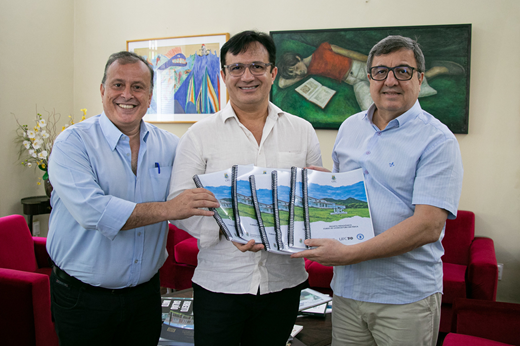 Da esquerda para a direita: Prof. Márcio Veras (diretor do Campus de Itapajé), Prof. Custódio Almeida (reitor) e Danilo Forte (deputado federal) seguram os projetos pedagógicos dos seis novos cursos planejados para o Campus Jardins de Anita. (Foto: Ribamar Neto/ UFC Informa) Imagem: De pé, da esquerda para a direita: Prof. Márcio Veras (diretor do Campus de Itapajé), reitor Custódio Almeida e deputado federal Danilo Forte seguram exemplares dos projetos pedagógicos dos seis cursos planejados para Itapajé. (Foto: Ribamar Neto)