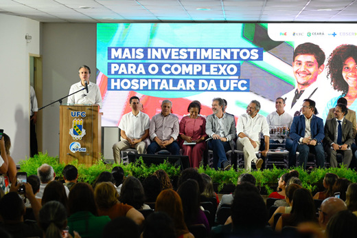 Camilo Santana anunciou que os recursos de custeio necessários para a manutenção da ampliação do Complexo Hospitalar já estão garantidos pela EBSERH. (Foto: Viktor Braga/ UFC Informa) Imagem: Ministro Camilo Santana discursa no púlpito do auditório; o público aparece de costas