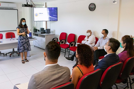 A fundadora e pesquisadora do GREat, Prof. Rossana Andrade, informou que o laboratório possui uma parceria desde 2020 com a Huawei, com três projetos já realizados conjuntamente (Foto: Ribamar Neto/UFC) Imagem: foto de uma mulher branca de óculos de grau fazendo e de vestido preto e branco em pé falando para um público sentado