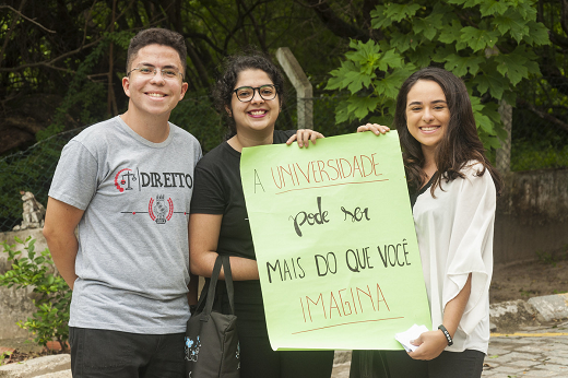 No SISU 2022, a UFC oferta 6.358 vagas, divididas em 113 cursos de graduação presencial (Foto: Viktor Braga/UFC) Imagem: Três estudantes, sendo que duas delas seguram um cartaz no qual está escrito "A universidade pode ser mais do que você imagina" (Foto: Viktor Braga/UFC) "