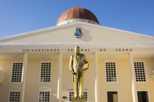Campus de Sobral da UFC foi fundado em 2006 (Foto: Ribamar Neto/UFC) Imagem mostra parte da fachada do campus de Sobral da UFC, com estátua na cor dourada a frente e céu azul ao fundo