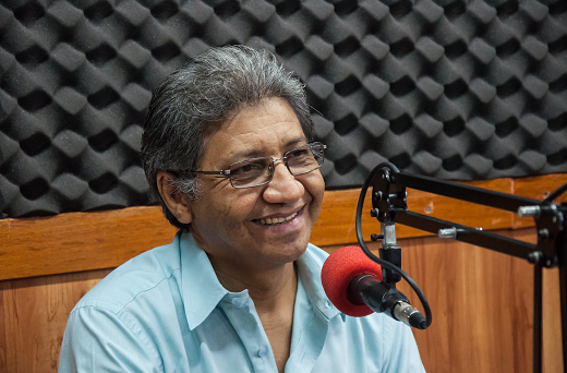O programa é apresentado pelo jornalista Nonato Lima, professor do Curso de Jornalismo da UFC (Foto: Viktor Braga/UFC) Imagem: Professor Nonato Lima no estúdio da rádio Universitária FM, sorrindo próximo a um microfone (Foto: Viktor Braga/UFC)
