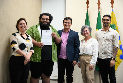 Ao todo foram empossados 17 servidores docentes aos campi da Instituição em Fortaleza e no Interior (Foto: Viktor Braga/UFC Informa) Imagens: Homem segurando termo de posse ao lado de pessoas da administração superior da UFC
