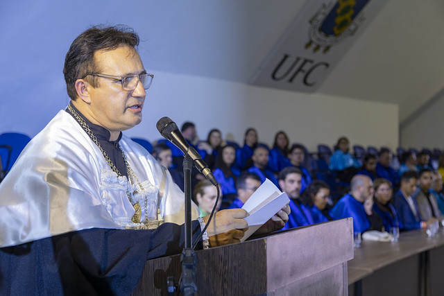 Em seu discurso, o reitor Custódio Almeida destacou que a colação de grau representa o encontro entre políticas públicas e trajetórias pessoais, oportunidade e esforço (Foto: Guilherme Silva/UFC) Imagem: homem vestido de veste talar discursa em um púlpito