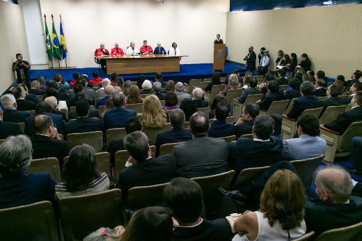 A saudação inicial aos laureados foi feita pelo Prof. Maurício Benevides, diretor da Faculdade de Direito (Foto: Gutierrez Reges/UFC Informa) Imagem: Imagem: ambiente de auditório com público sentado e a mesa formada ao fundo com autoridades