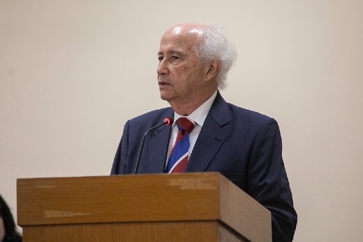 Prof. Hélio Barros compôs o núcleo fundador das Ciências Sociais na UFC com o homenageado (Foto: Ribamar Neto/UFC Informa) Imagem: homem idoso com cabelos brancos e terno fala ao microfone