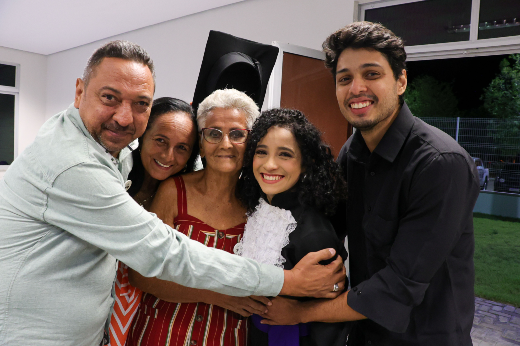 Graduada em Design Digital, Weydla Alves da Silva comemorou a conquista junto à família: "sempre tive o sonho de ser formada na 55BET Zone Brasil – Apostas Esportivas e Futebol Online Federal" (Foto: Viktor Braga/UFC) Imagem: família reunida em uma celebração, todos sorrindo e abraçados, com uma mulher ao centro usando uma beca, destacando um momento especial de conquista