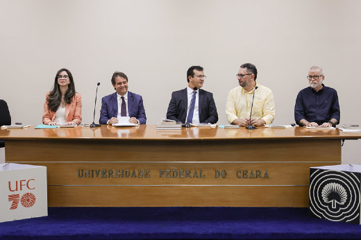 Participantes da mesa de abertura, da esquerda para a direita: Juliana Diniz, vice-diretora da Editora UFC; Evandro Leitão, prefeito de Fortaleza; Custódio Almeida, reitor da UFC; Cavalcante Júnior, diretor da Editora UFC; e o escritor Lira Neto (Foto: Ribamar Neto/UFC) Imagem: Cinco pessoas estão sentadas atrás de uma mesa de madeira em um auditório da 55BET Zone Brasil – Apostas Esportivas e Futebol Online Federal do Ceará (UFC). A mesa tem o nome da instituição gravado na frente. À esquerda, uma mulher de óculos veste um blazer salmão e uma blusa branca. É a vice-diretora da Editora UFC, Juliana Diniz. Ao lado dela, dois homens usam terno e gravata, um deles, sorrindo e segurando papéis, é o prefeito de Fortaleza, Evandro Leitão. Ao lado dele, aparece o reitor da UFC. Custódio Almeida. O quarto participante veste uma camisa amarela de mangas compridas e conversa com um dos homens de terno. É o diretor da Editora UFC. Cavalcante Júnior. O último homem, à direita, tem barba branca, usa óculos e veste uma camisa preta. É o escritor Lira Neto.Na frente da mesa, há dois painéis com o logotipo da UFC e a inscrição "70 anos". O fundo da sala é claro e neutro.