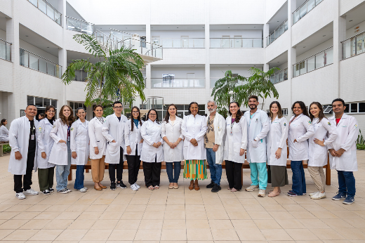 Imagem: equipe de pesquisadores, vestindo jaleco, posam para fotografia