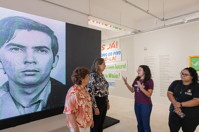 Imagem: quatro mulheres conversam em espaço expositivo