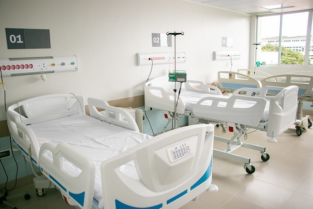 Durante o mês de maio, o mutirão deve atender mais de 100 pacientes para realização de procedimentos hepáticos e oftalmológicos (Foto: Ribamar Neto/ UFC) Imagem: A imagem mostra um quarto hospitalar moderno e bem iluminado. No ambiente, há três leitos hospitalares numerados (01, 02 e 03), todos equipados com camas ajustáveis eletronicamente, com controles embutidos nas laterais das camas. Cada leito possui também um painel na parede com botões de chamada de enfermagem e conexões para gases medicinais (oxigênio, ar comprimido, etc.), além de suportes para equipamentos intravenosos. O ambiente é limpo, organizado e claro, com iluminação natural vinda de uma janela ampla ao fundo, o que contribui para uma atmosfera mais acolhedora e confortável para os pacientes.