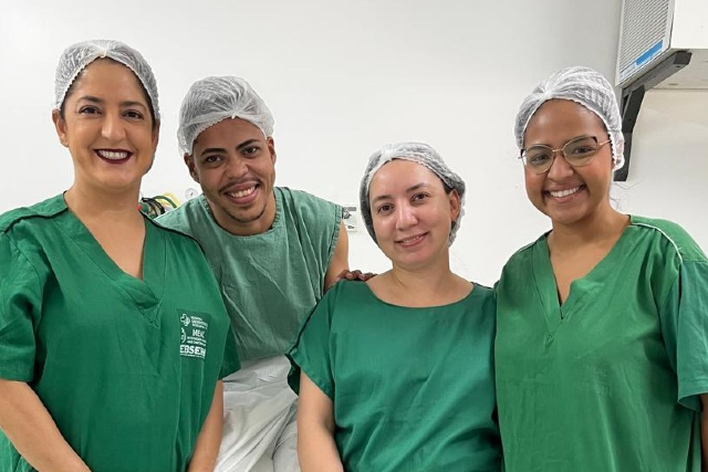 Imagem: paciente mastectomizado ao lado de profissionais de saúde