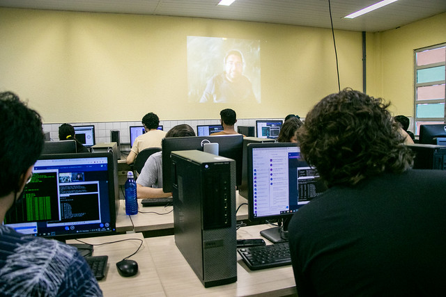 Imagem: estudantes manuseiam computadores em aula do curso de Sistemas e Mídias Digitais