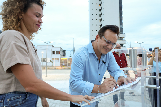 Imagem: Na Praça Cultural São Pedro, a secretária Luisa Cela e o reitor Custódio Almeida assinam o termo de cooperação. 