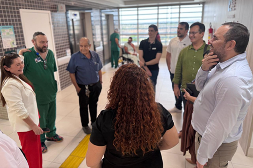 Imagem: Dispostos em círculo, integrantes da comitiva da UFC conversam no saguão do hospital com representante da diretoria do HRVJ