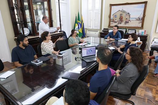Imagem: Participantes da reunião sentados à mesa no Gabinete da Reitoria